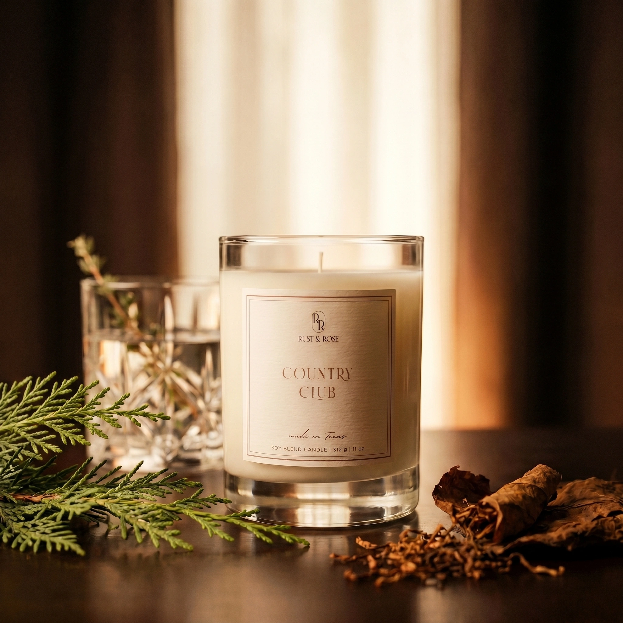 Candle labeled 'Country Club' with decorative elements on a dark background