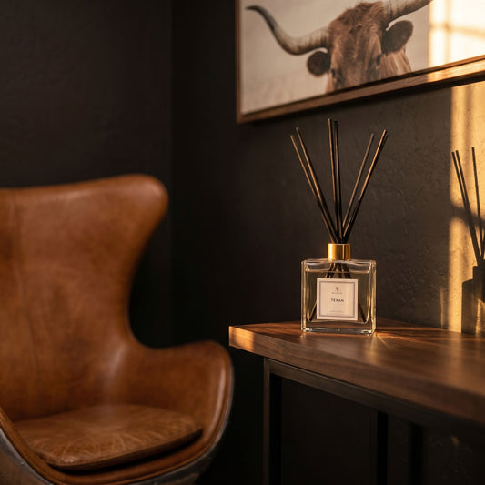 Decorative diffuser on a table next to a brown leather chair with a dark wall and bull head artwork in the background.