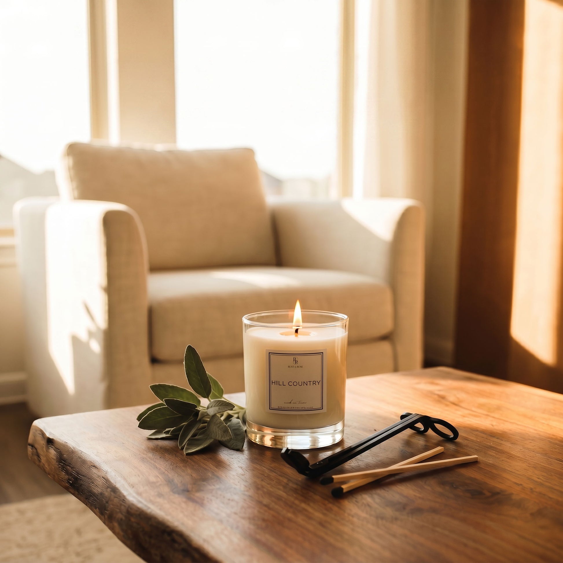 Candle on a wooden table with a beige armchair in the background