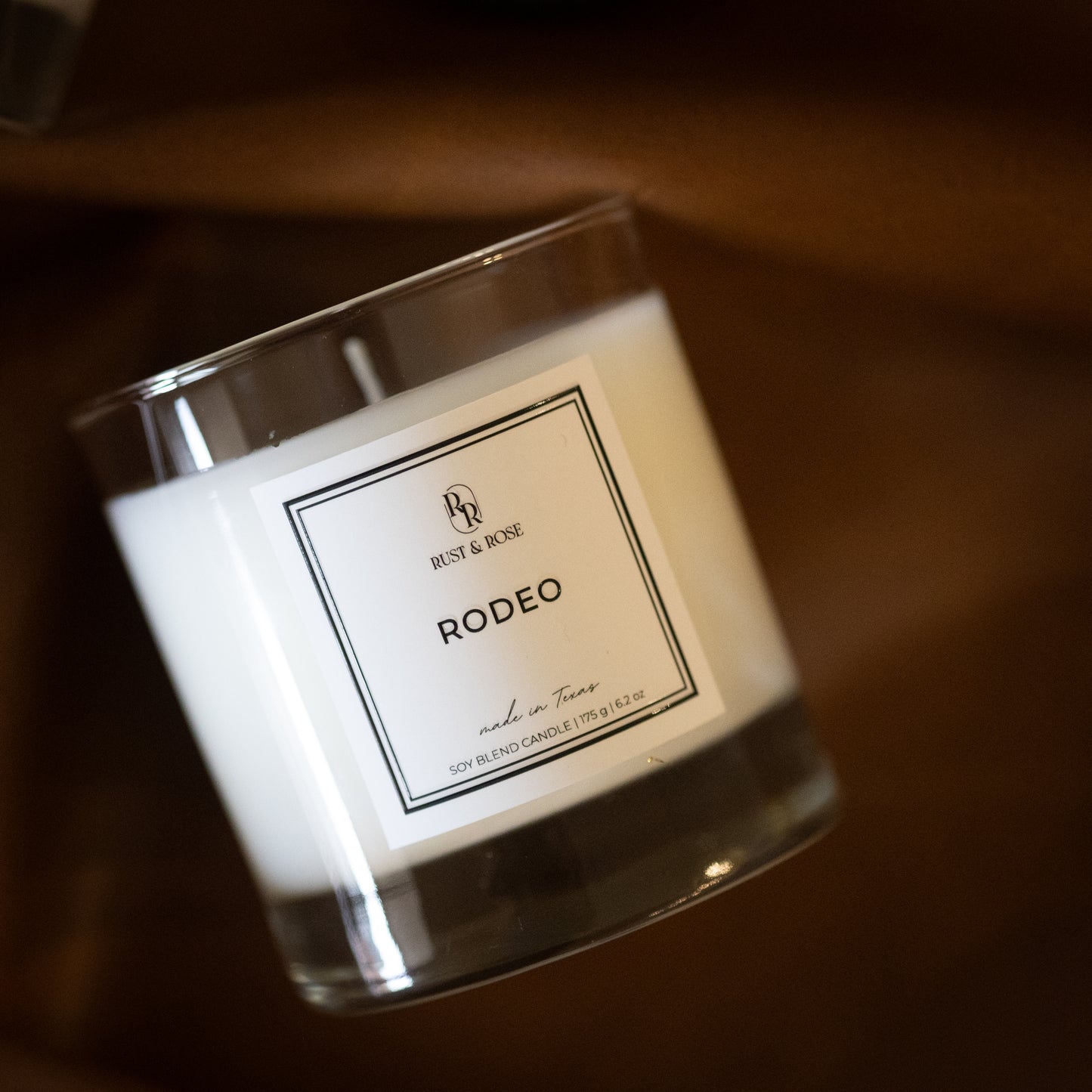 Candle with a label on a wooden surface