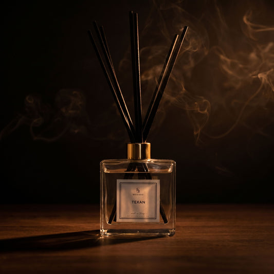 Clear diffuser bottle with black sticks and 'Texan' label on a dark background