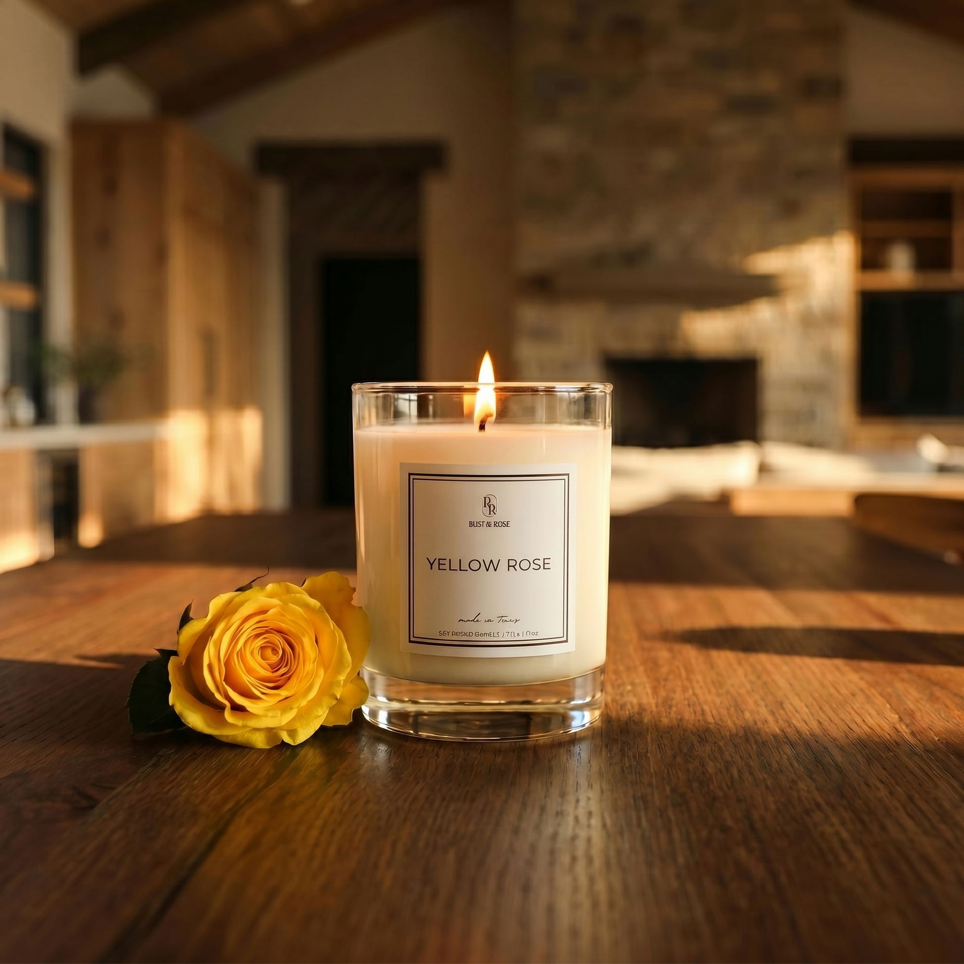 Candle labeled 'Yellow Rose' with a yellow rose on a wooden surface in a warm, indoor setting.